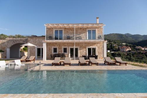 a villa with a swimming pool in front of a house at Villa Sunset, stunning villa rental in Corfu by PosarelliVillas in Perítheia