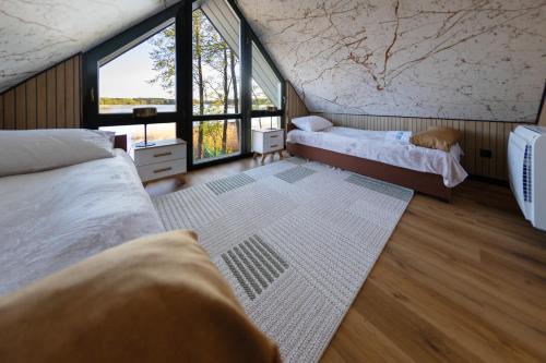 a bedroom with two beds and a large window at OSTOJA Ciernie in Ciernie