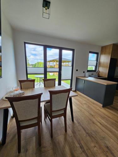 a kitchen and dining room with a table and chairs at Zielony Zakątek in Ramleje