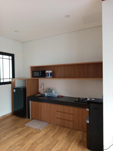 a kitchen with wooden cabinets and a black counter top at Villa Shizuka Garut in Garut
