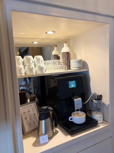 a counter with a coffee maker and a cup of coffee at Hôtel Moderna in Cherbourg en Cotentin