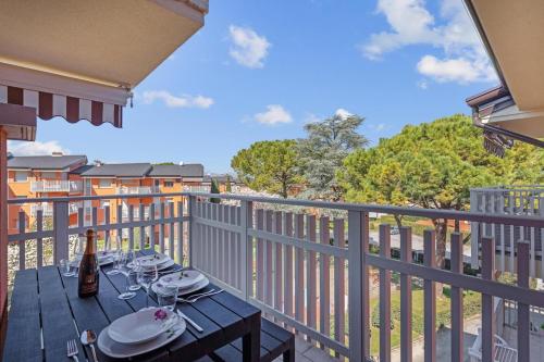a wooden table with wine glasses on a balcony at 200mt Lake - Flower Home with Pool & Tennis in Peschiera del Garda