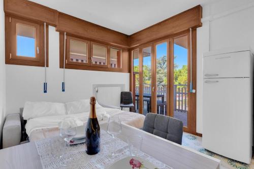 a living room with a bottle of wine on a table at 200mt Lake - Flower Home with Pool & Tennis in Peschiera del Garda