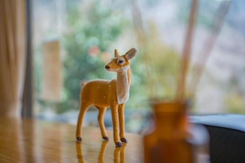 a toy deer standing on a wooden floor at 仙石原Yorokobu 金時ヒルハウス 金時山登山に便利 BBQ in Sengokuhara