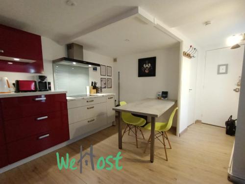une cuisine avec une table et des chaises dans une pièce dans l'établissement Historic comfortable one bedroom apartment in center, à La Rochelle