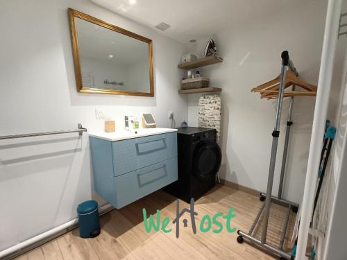 La salle de bains est pourvue d'une commode bleue et d'un miroir. dans l'établissement Historic comfortable one bedroom apartment in center, à La Rochelle