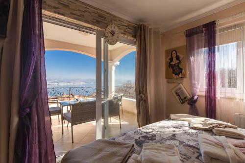 a bedroom with a bed and a view of a balcony at Luxury Villa Emily with Private Infinity Pool Breathtaking Adriatic Views in Opric