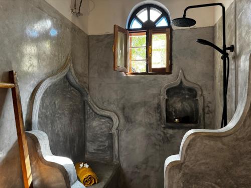 a bathroom with stairs and a sink and a window at ZamZam House in Jambiani