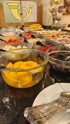 ヴィリンゲンにあるHotel Garni "Zur Alten Post"のたくさんの食べ物の入ったボウルが置かれたテーブル