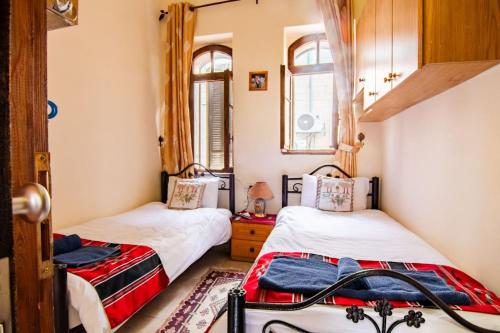 two beds in a room with two windows at BREAD HOUSE in Bethlehem