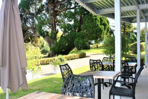 a patio with a table and chairs and an umbrella at Domaine AGERRIA in Mauléon-Licharre
