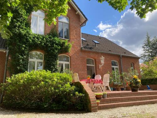 a house with a table and chairs in front of it at Landhaus Amalie in Malchow