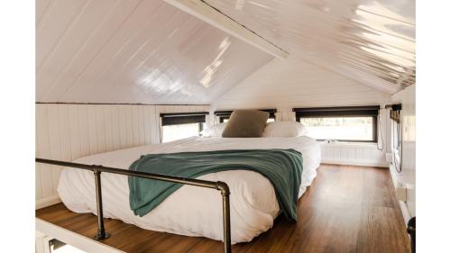 un letto nel mezzo di una casetta di Odyssean Tiny House A by Tiny Away a Cessnock