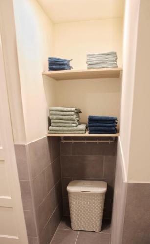a bathroom with a closet with a toilet and towels at Vakantiehuis de Schuur in Munstergeleen