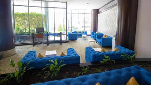 a waiting room with blue chairs and a television at Signature Hotel Apartments and Spa in Dubai