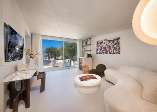 a living room with a couch and a table at Destino Five Ibiza - 5-Star Grand Luxe Resort in Talamanca