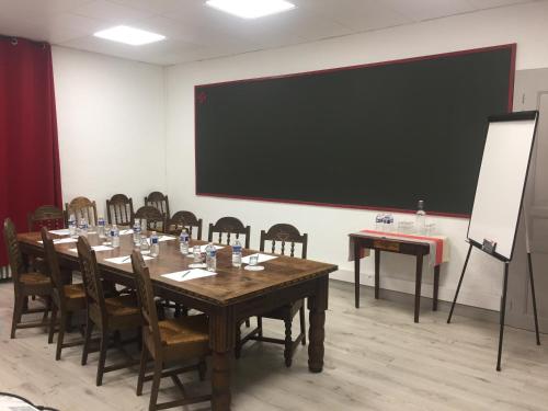 a conference room with a table and chairs and a blackboard at Domaine AGERRIA in Mauléon-Licharre