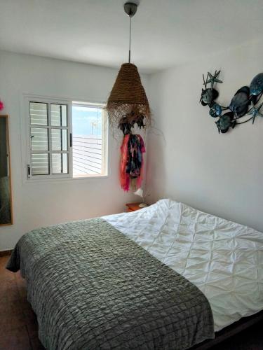 a bedroom with a bed and a window at Sunny Bungalow in Caleta De Fuste