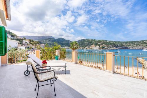 a balcony with a table and a bench and the water at Sa Caleta in Port de Soller