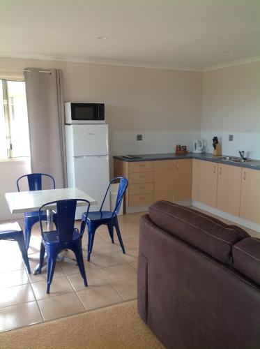 a living room with a couch and a table and a kitchen at Lake Barra Cottages in Downsfield
