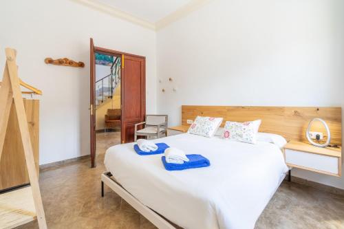 a bedroom with a large white bed with blue towels on it at Sa Caleta in Port de Soller