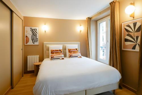 une chambre avec un lit blanc avec deux oreillers dessus dans l'établissement Duplex climatisé - Grands Boulevards, à Paris