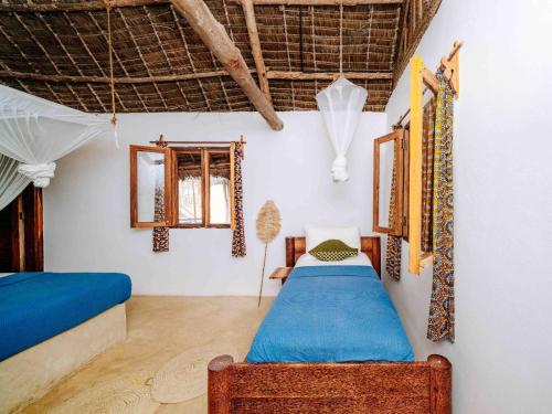 a bedroom with two beds in a room at Shanuo Beach Bungalows in Michamvi