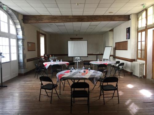 a large room with tables and chairs and a projection screen at Domaine AGERRIA in Mauléon-Licharre