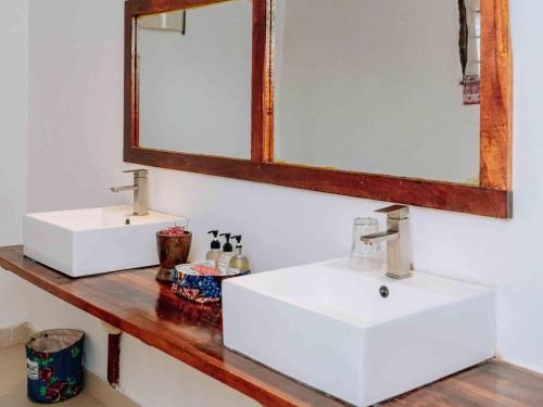 a bathroom with two sinks and a mirror at Shanuo Beach Bungalows in Michamvi
