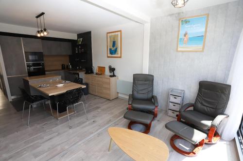un salon avec une table et des chaises et une cuisine dans l'établissement Superbe appart cosy au ceur de St Cyprien, à Saint-Cyprien