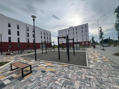 a park with a bench and some buildings at Tirana Airport Apartment in Tirana
