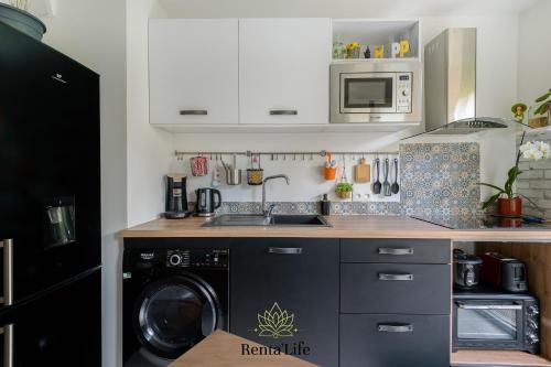 une cuisine avec un lave-linge et un lave-linge dans l'établissement Au jardin de Chessy - T2 - 5min DisneyLand, à Chessy