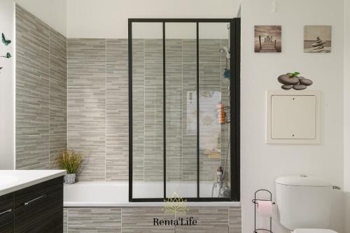 une salle de bain avec une douche avec une porte vitrée dans l'établissement Au jardin de Chessy - T2 - 5min DisneyLand, à Chessy