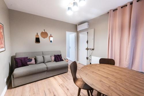 un salon avec un canapé et une table dans l'établissement Appartement cosy climatisé 1BR - Gare de Lyon, à Paris