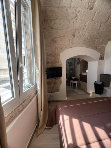 a bedroom with a bed and a large window at La Fiumara - Room with Bathroom in Bitonto