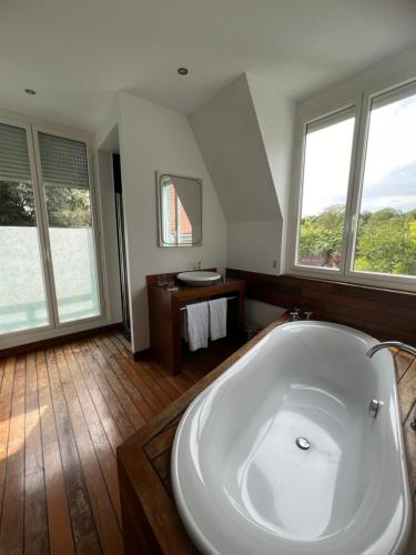 a large white bath tub in a room with windows at Domaine De La Corniche in Rolleboise