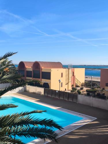 - une vue sur un bâtiment avec piscine dans l'établissement Location de vacances bord de mer Gruissan, à Gruissan