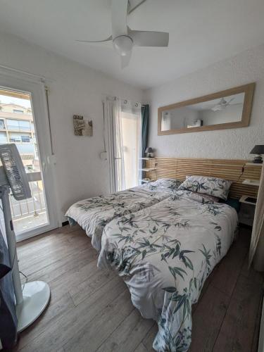 une chambre avec un lit et une grande fenêtre dans l'établissement Vue imprenable sur la mer, à Port-la-Nouvelle