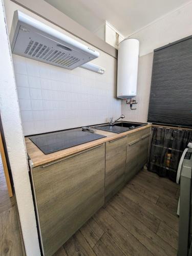 une cuisine avec un évier et une cuisinière dans l'établissement Vue imprenable sur la mer, à Port-la-Nouvelle