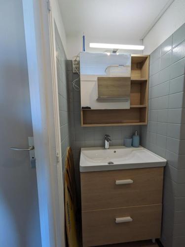 une petite salle de bain avec un lavabo et un miroir dans l'établissement Vue imprenable sur la mer, à Port-la-Nouvelle