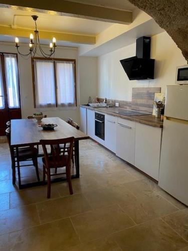 Il comprend une cuisine équipée d'une table et d'un réfrigérateur. dans l'établissement Agnès, à Montagnac