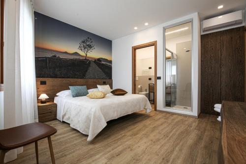 a bedroom with a bed and a painting on the wall at La Giuggiola in Arqua Petrarca