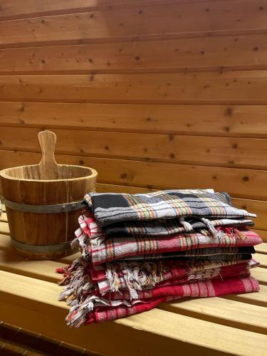 a stack of blankets on a table next to a wooden bowl at Landhotel Jägerhof in Bischofsgrün