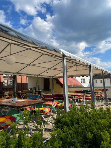 a pavilion with a table and chairs under it at Landhotel Jägerhof in Bischofsgrün