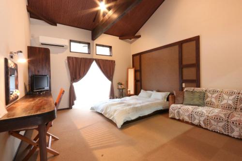 ein Schlafzimmer mit einem Bett und einem Sofa in der Unterkunft Sunny Spot in Minamitan
