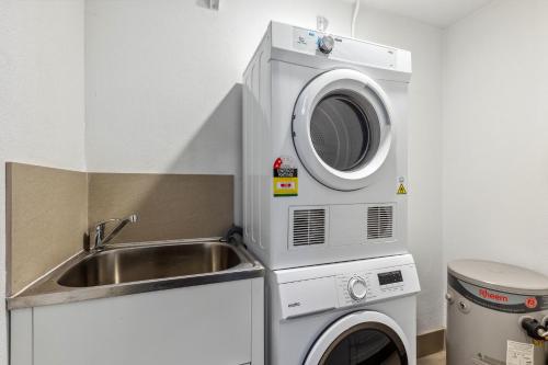 a kitchen with a sink and a washing machine at Yaran Suites in Rockingham