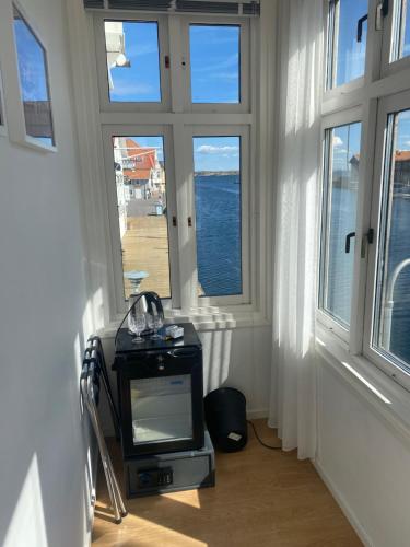 a room with a tv in a room with windows at Pensionat bryggan in Smögen