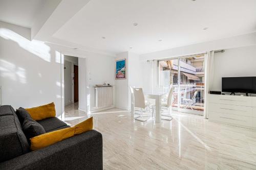 un salon avec un canapé et une table dans l'établissement LE LOUIS BLANC avec balcon en plein centre-ville, à Cannes