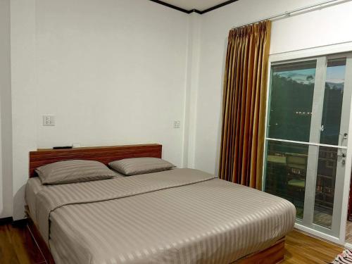 a bedroom with a bed and a large window at Lake View @Rakthai in Ban Thung Kha Han