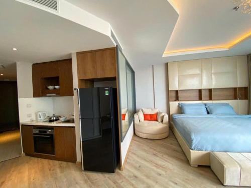 a bedroom with a large bed and a kitchen at Moonlight Bay Panorama Condotel Ocean View in Nha Trang